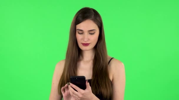 若い女性は彼女の電話でテキストメッセージとショックを受けた。緑の画面 — ストック動画