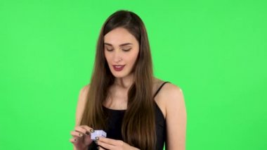 Kız sürpriz bir şekilde küçük bir kutu açıyor ve gördüklerinden çok hayal kırıklığına uğruyor. Yeşil Ekran