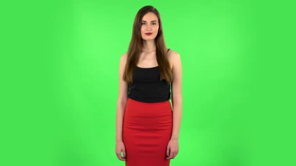 Γυναίκα στέκεται, απλώνεται με χαμόγελο και κοιτάζει την κάμερα. Πράσινη οθόνη — Αρχείο Βίντεο