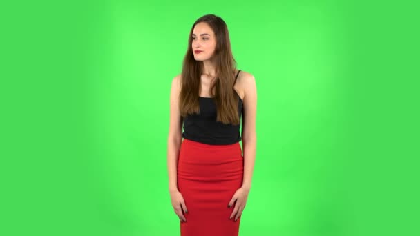 Молода жінка стоїть чекаючи на зеленому екрані — стокове відео