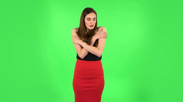 Mooi zoet meisje bevroor en proberen om warm te houden tegen groen scherm — Stockvideo