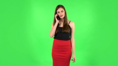 Gülümseyen kız cep telefonu için konuşuyor ve seviniyor. Yeşil Ekran