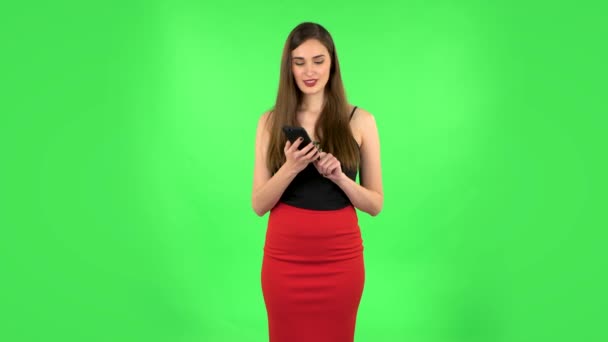 Mädchen bittet um Informationen über das Netzwerk per Telefon auf grünem Bildschirm — Stockvideo
