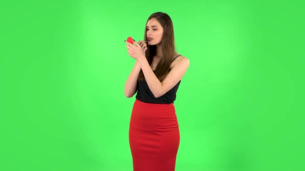 Girl paints her lips looking in red mirror. Green screen — Stock Video