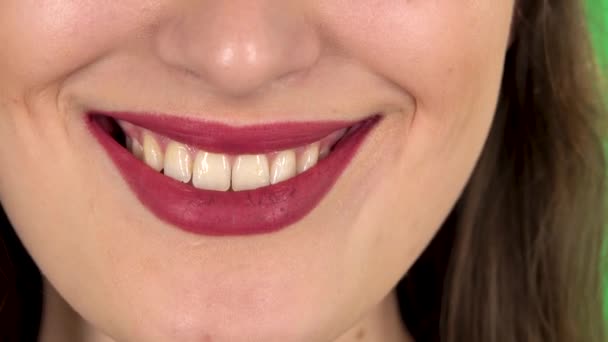 Mujer joven con labios rojos sonriendo revelando dientes. De cerca. — Vídeos de Stock
