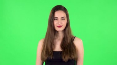 Sevimli kız gülümser, parmaklarıyla kalbini gösterir ve öpüşür. Yeşil Ekran