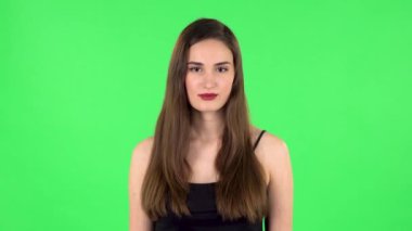 Masum olduğunu belirterek ellerini kusturan öfkeli bir kadın, parmağını şakağına doğru büker. Yeşil Ekran