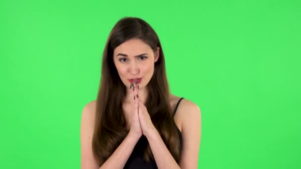 Girl keeps palm together and asks for something. Green screen — Stockvideo