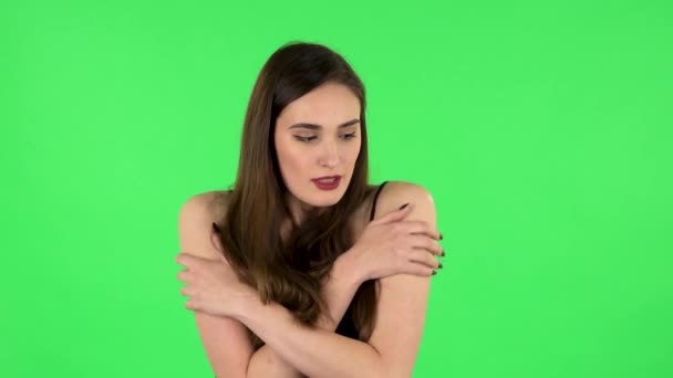 Mooi zoet meisje bevroor en proberen om warm te houden tegen groen scherm — Stockvideo