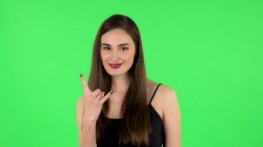 Kadın taş gibi bir jest yapıyor, hayattan zevk alıyor ve gülüyor. Yeşil Ekran