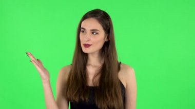 Kadın bir şey için elini kaldırıyor sonra başını sallıyor ve başparmağını gösteriyor. Yeşil Ekran