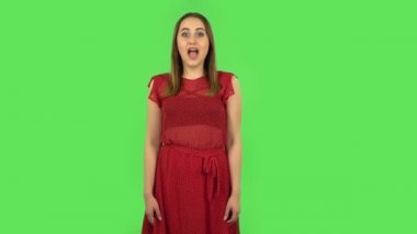 Tender girl in red dress with shocked surprised wow face expression. Green screen