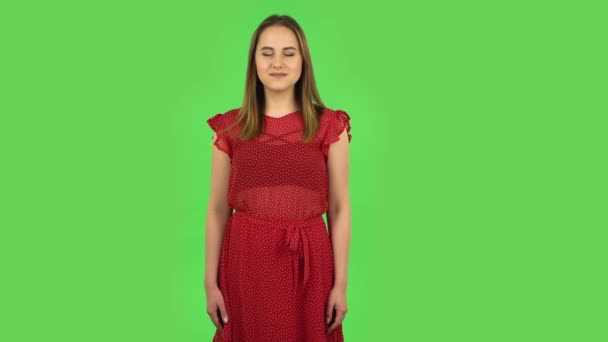 Tender girl in red dress is smiling while looking at camera. Green screen — Αρχείο Βίντεο