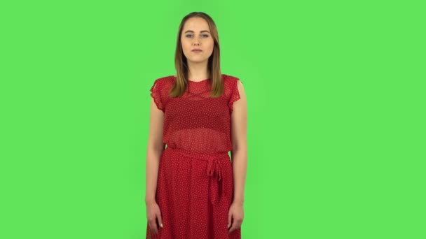 Tender girl in red dress is saying wow with shocked facial expression. Green screen — 비디오