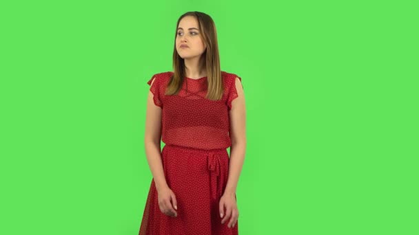 Chica tierna en vestido rojo está esperando. Pantalla verde — Vídeo de stock