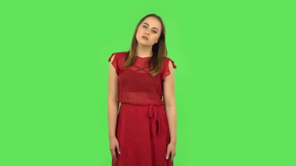 Tender girl in red dress is upset and tired. Green screen — Wideo stockowe