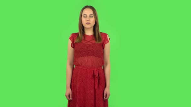 Tender girl in red dress is thinking about something, and then an idea coming to her. Green screen — ストック動画