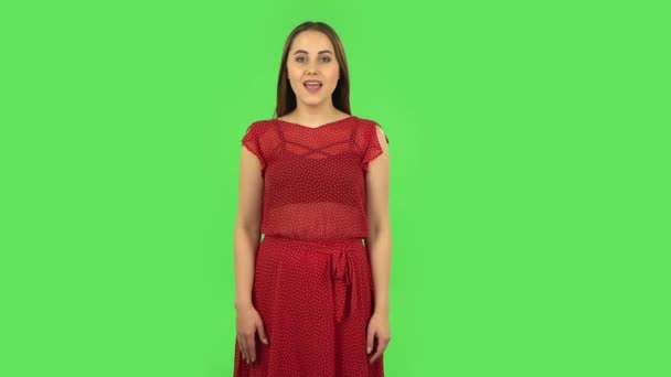 Tender girl in red dress is screaming calling someone. Green screen — Stock Video