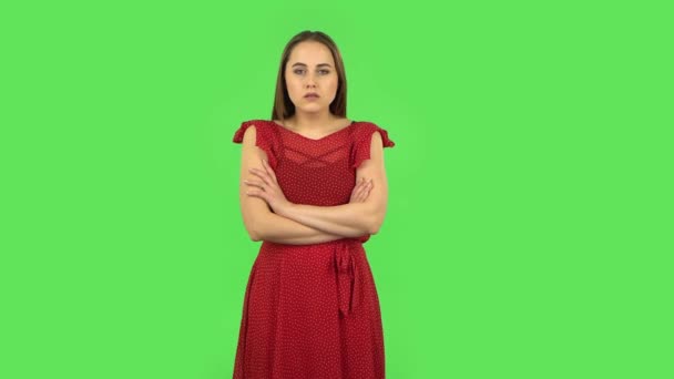 Dziewczyna w czerwonej sukience słucha informacji, zszokowana i uśmiechnięta. Zielony ekran — Wideo stockowe