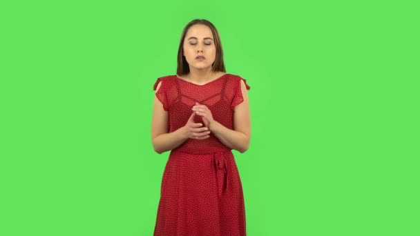 Zartes Mädchen in rotem Kleid hört den Informationen zu, schockiert und sehr aufgebracht. Grüner Bildschirm — Stockvideo