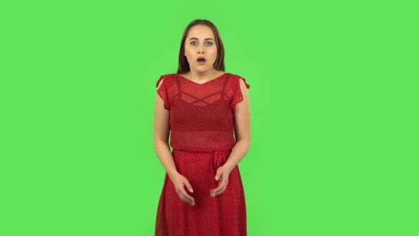 Chica tierna en vestido rojo está escuchando información, sorprendido y muy molesto. Pantalla verde — Vídeo de stock