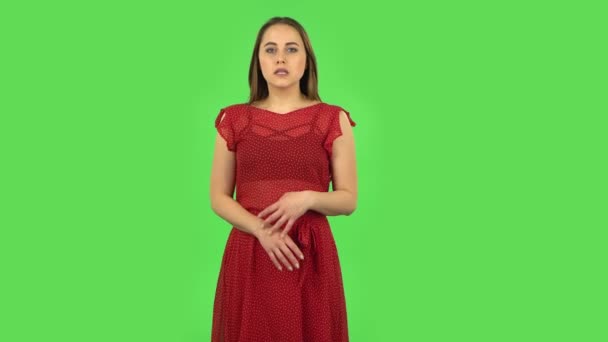 Gyengéd lány piros ruhában, az aggodalomra várva, aztán a bűnös elrejti a szemét. Zöld képernyő — Stock videók