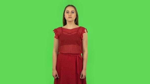 Ragazza tenera in abito rosso sta mostrando i pollici verso il basso gesto. Schermo verde — Video Stock