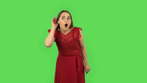 Zartes Mädchen hält Hand in Ohr und versucht, interessante Nachrichten zu hören, die das Kommunikationskonzept zum Ausdruck bringen. Grüner Bildschirm — Stockvideo