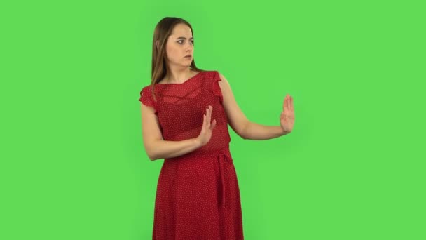 Chica tierna en vestido rojo estrictamente gesto con las manos forma lo que significa negación diciendo NO. Pantalla verde — Vídeos de Stock