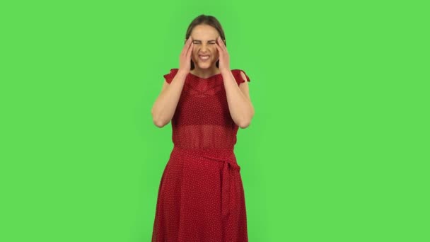 Das zarte Mädchen im roten Kleid leidet unter Müdigkeit und Kopfschmerzen. Grüner Bildschirm — Stockvideo