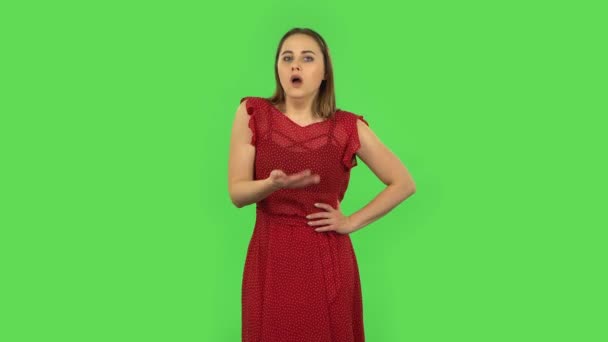 Menina macia em vestido vermelho está esfriando-se por sua mão, sofrendo de clima de alta temperatura. Tela verde — Vídeo de Stock