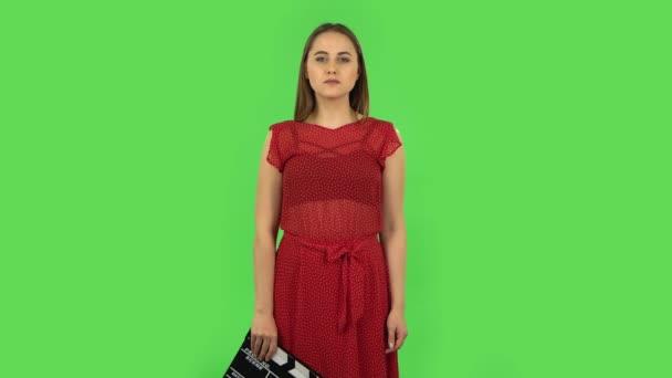 Menina macia em vestido vermelho está segurando um filme em suas mãos. Tela verde — Vídeo de Stock