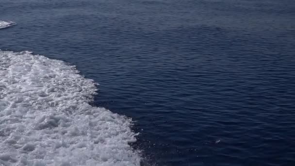 Wave flow view from ship. Slow motion view sea wave behind pleasure vessel at sunny day — Wideo stockowe