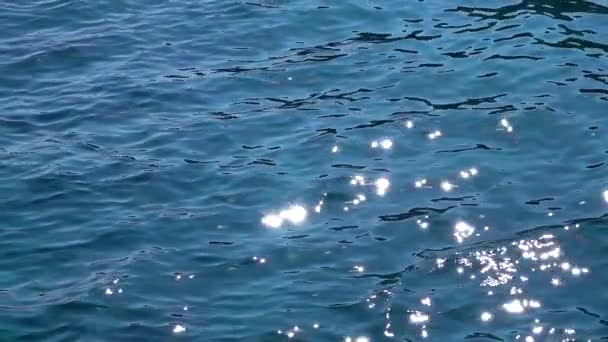 Ondas de agua turquesa en alta mar con reflejos de rayos solares. En cámara lenta. De cerca. — Vídeos de Stock