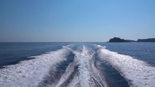 Vista en cámara lenta del velatorio detrás de un barco en el mar en un día soleado . — Vídeo de stock