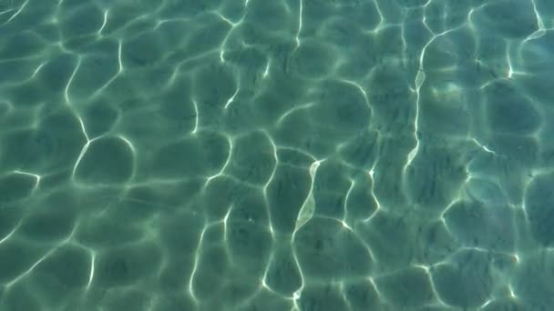 Turquoise sea with clear water, sand and small fish are visible at the bottom. Slow motion. Close up — 비디오