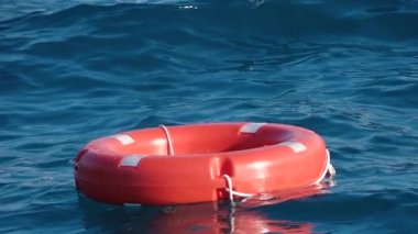 Life buoy or rescue buoy floating on sea to rescue people from drowning man. Slow motion. Close up
