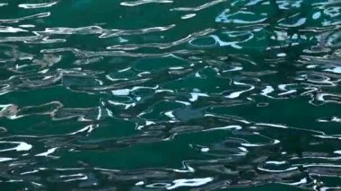 Sunny rays playing in the sea turquoise waves. Slow motion. Close up
