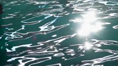 Turquoise water waves offshore with sun rays reflections. Slow motion. Close up
