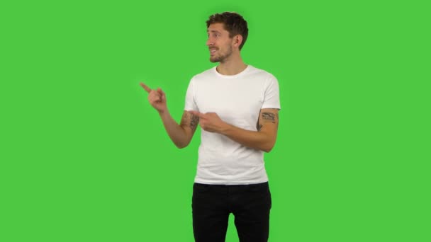 Selbstbewusster Typ zeigt mit der Hand auf etwas, nickt dann und zeigt den Daumen nach oben. Grüner Bildschirm — Stockvideo