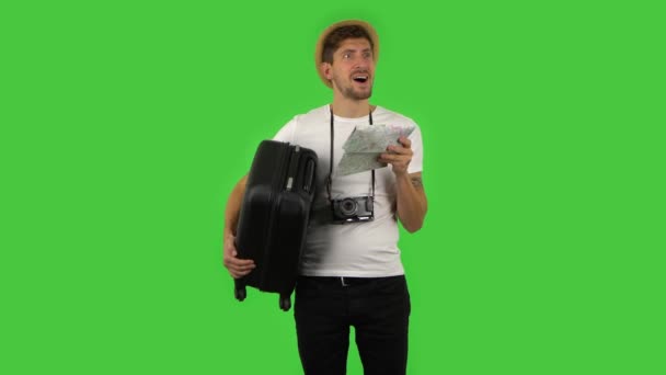 Tourist with suitcase in hand and retro camera examines the map, then attractions around and rejoicing. Green screen — Stock Video