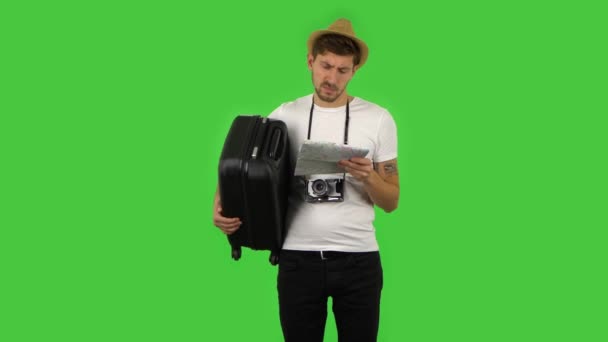 Touriste avec valise examine attentivement la carte, puis en regardant la caméra et dire wow, expression faciale choquée. Écran vert — Video