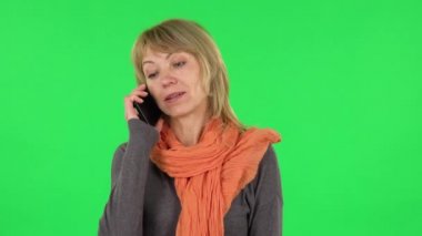 Orta yaşlı sarışın kadın portresi cep telefonu için konuşuyor. Yeşil Ekran