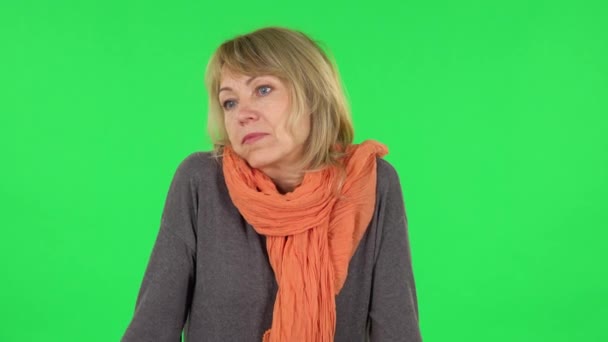 Portret van een blonde vrouw van middelbare leeftijd haalt haar schouders op en zucht. Groen scherm — Stockvideo