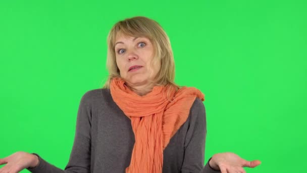 Portret van blonde vrouw van middelbare leeftijd praat verontwaardigd met iemand. Groen scherm — Stockvideo