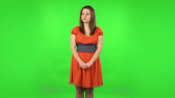 Cute girl examines something then fearfully covers her face with her hands. Green screen — Stock Video