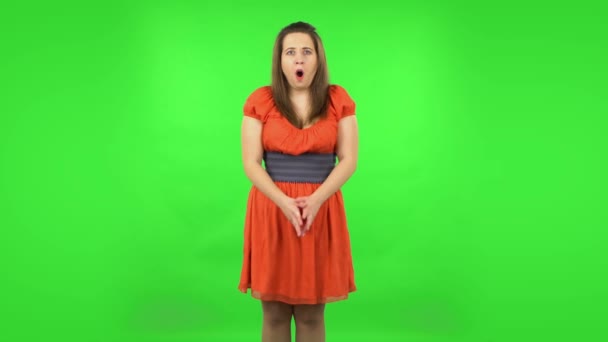Girl carefully examines something then fearfully covers her face with her hands. Green screen — Stock Video