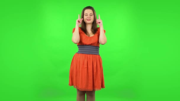 Menina bonito apontando dedos para cima para algo com espaço.. Tela verde — Vídeo de Stock