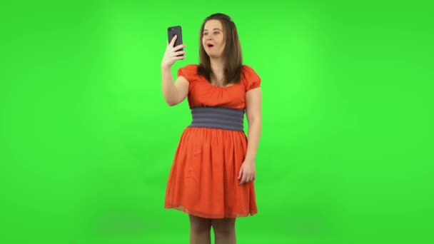 Cute girl talking for video chat using mobile phone and rejoice. Green screen — Stock Video