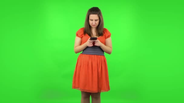 Roztomilá holka rozzlobeně píše na mobil. Zelená obrazovka — Stock video